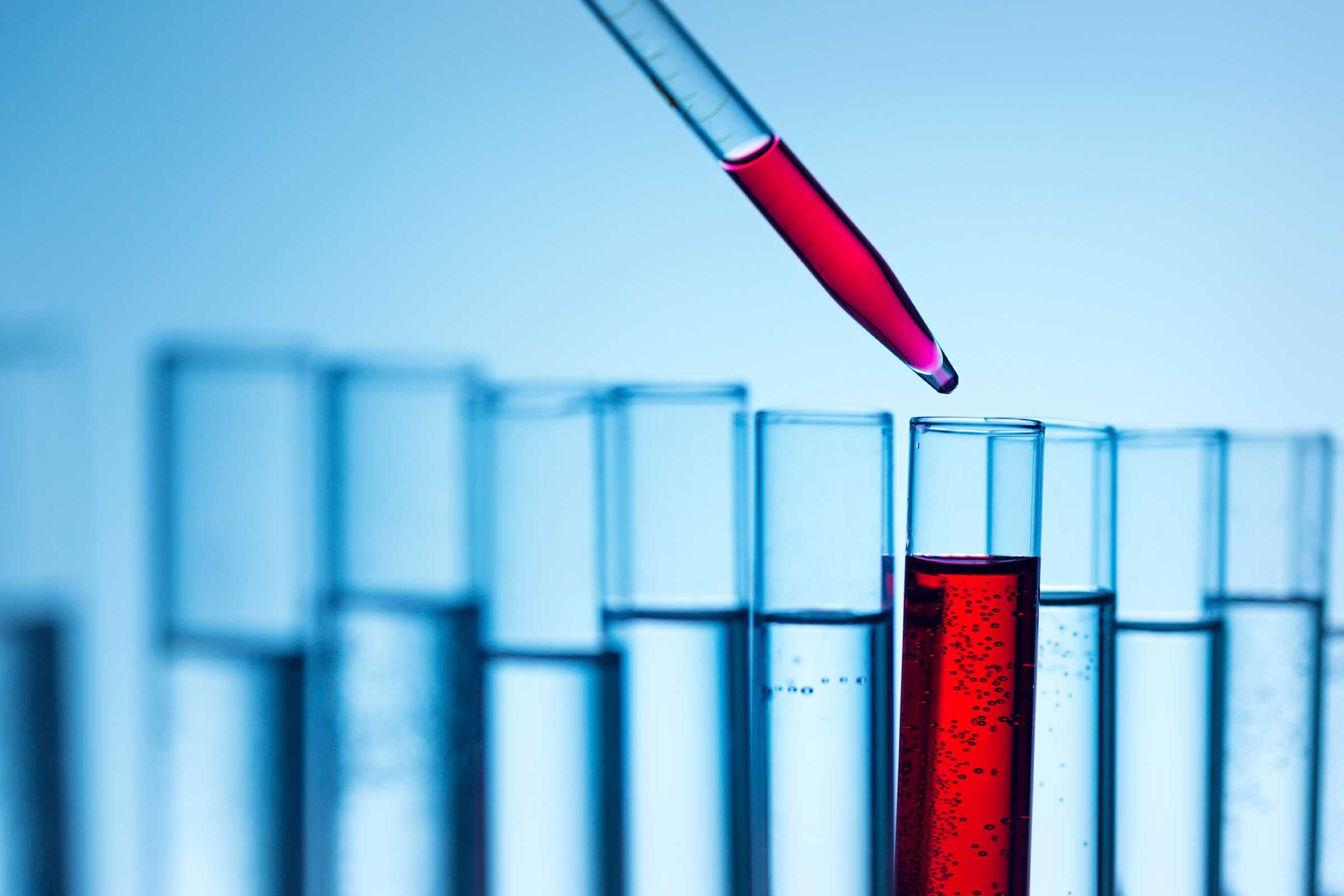 test tubes with liquid; dropper putting red fluid into one test tube