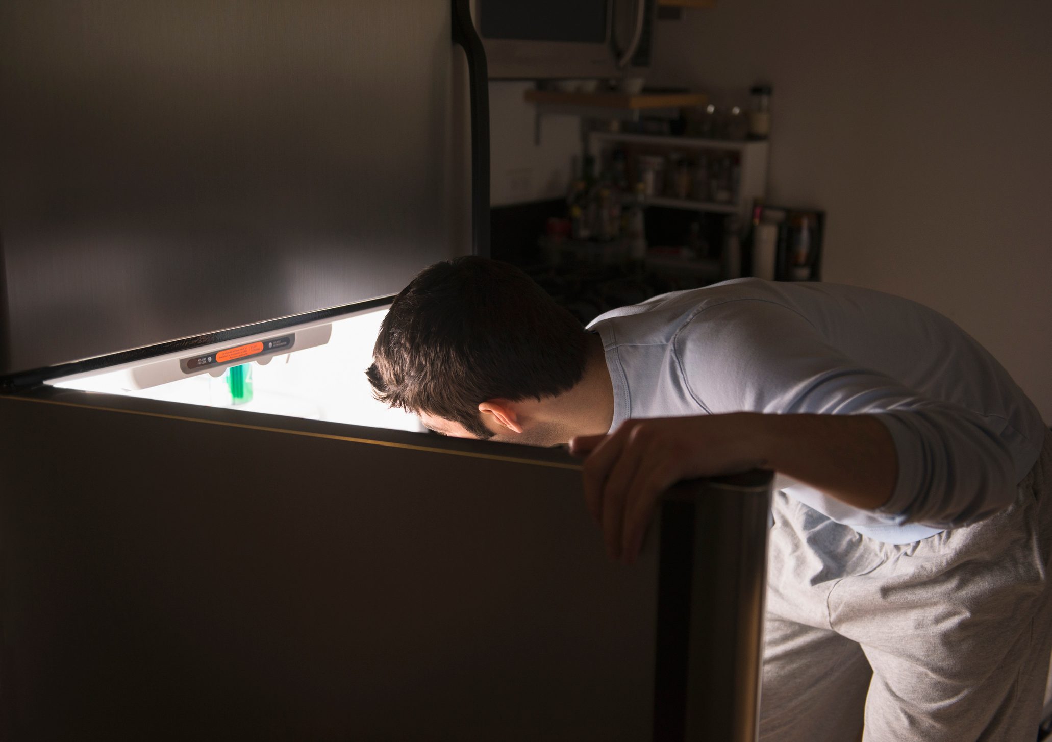 man opening refrigerator at night