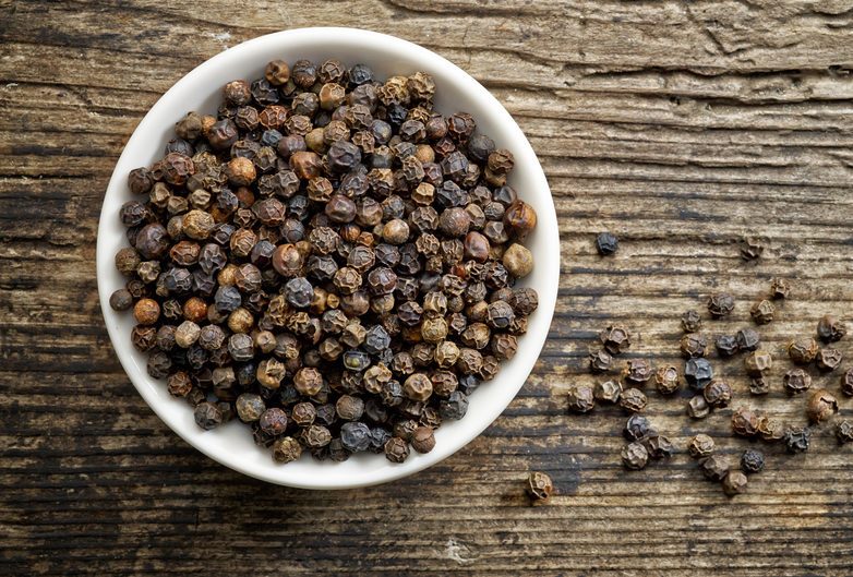 Bowl of whole black peppercorns