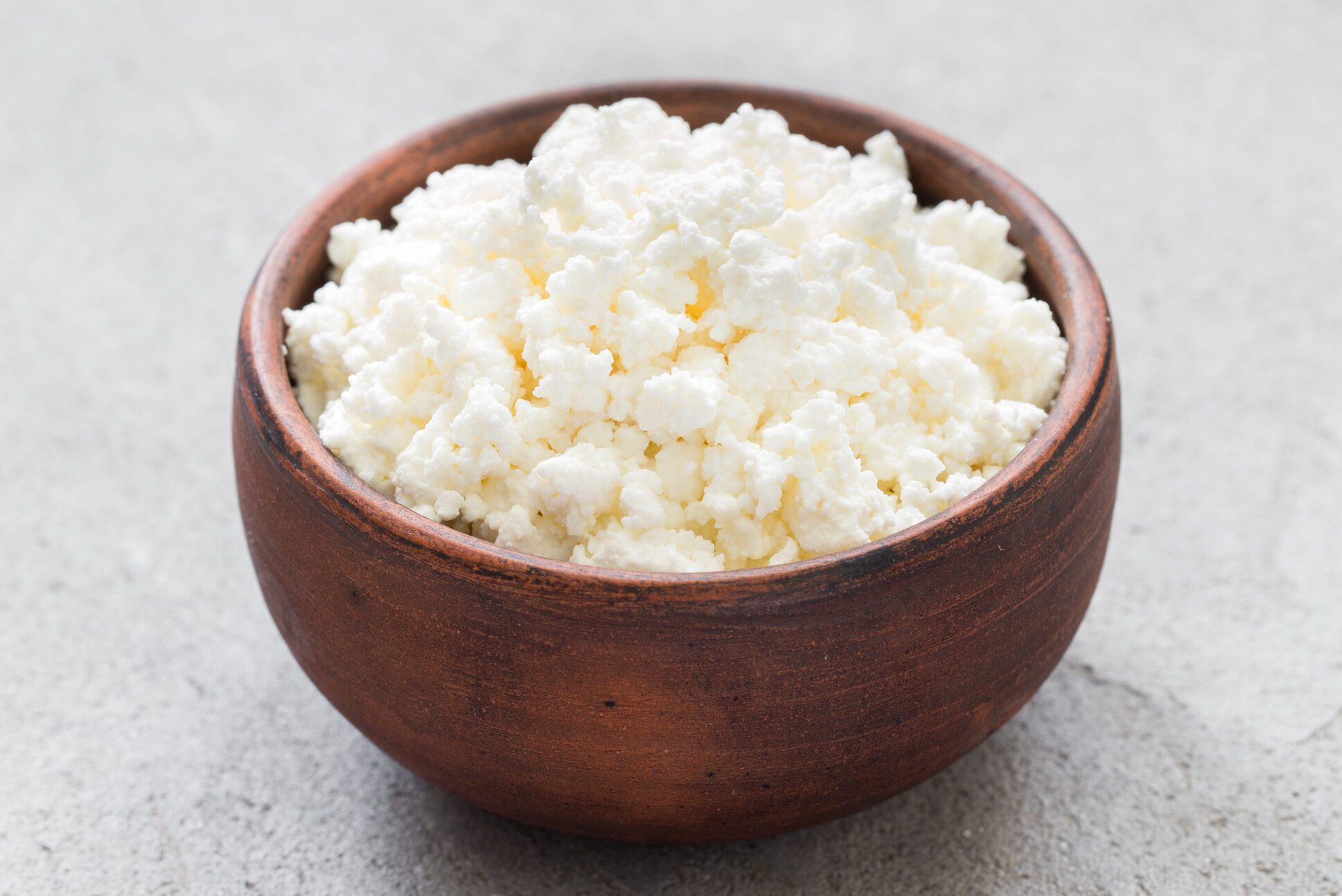 Freshly made cottage cheese in a clay bowl.