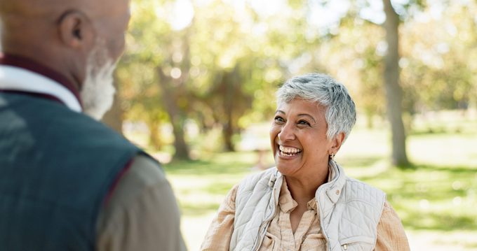 Love, Happy And Indian Woman In Park For Walk, Laugh And Talking In Retirement In Nature Or Forest. Partner, Diverse And Support Or Trust For Man And Female Person, Care And Conversation Together